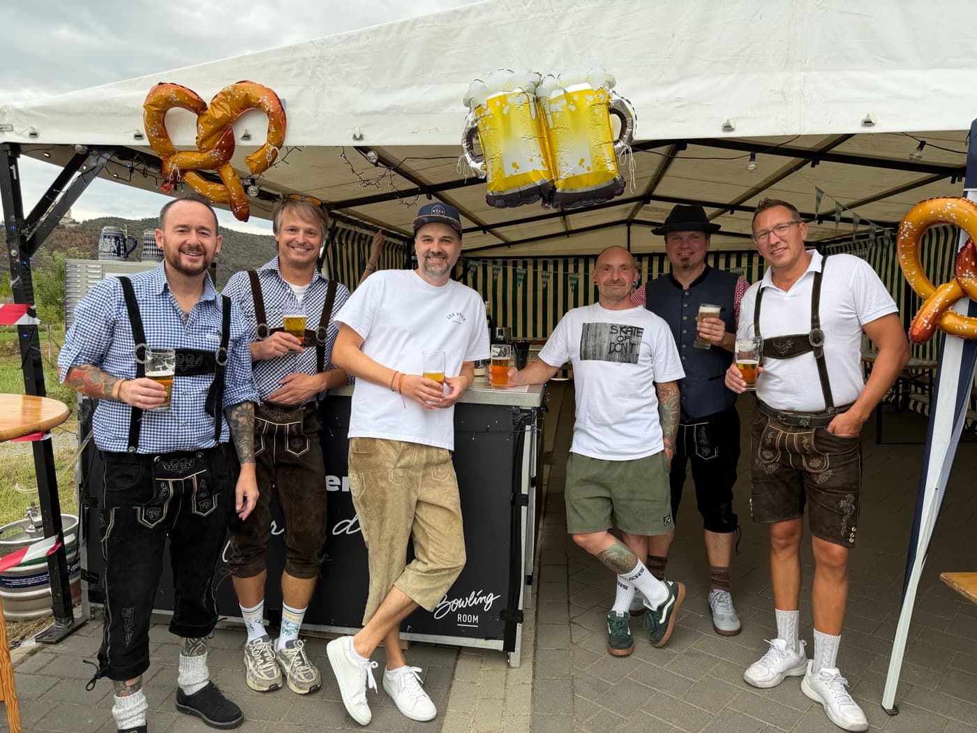 Das Orga-Team in Lederhosen an der Theke